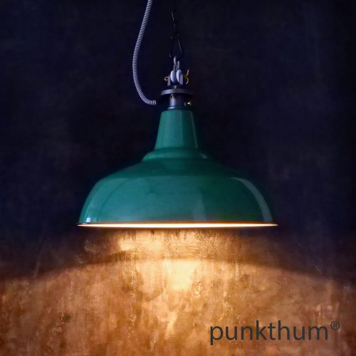 Grüne Emaillelampe, Industrielampe mit Stahlguss-Aufhängung und Textilkabel, eingeschaltet.