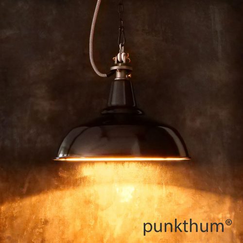 Schwarze Emaillelampe, Industrielampe mit Stahlguss-Aufhängung und Textilkabel, eingeschaltet.