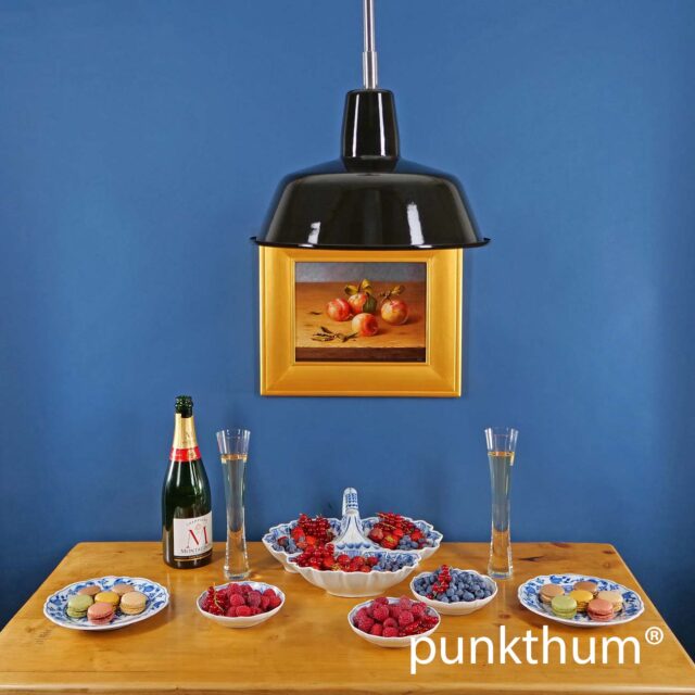 Schwarze Emaillelampe über dem Tisch, mit Stahlrohr-Aufhängung.