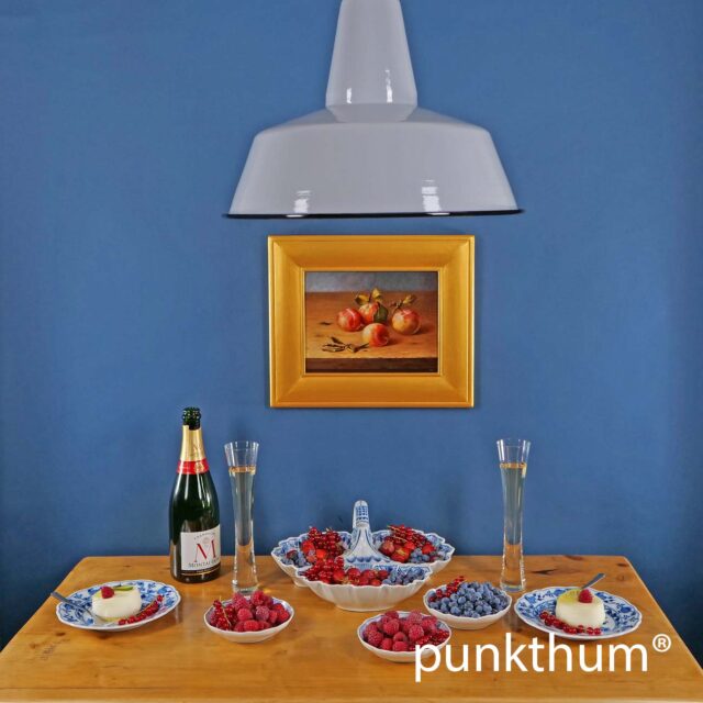 Große graue Emaillelampe über dem Tisch.